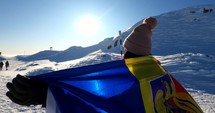 Girl walking with a Romanian Flag on top of The Bucegi Mountains in Romania.