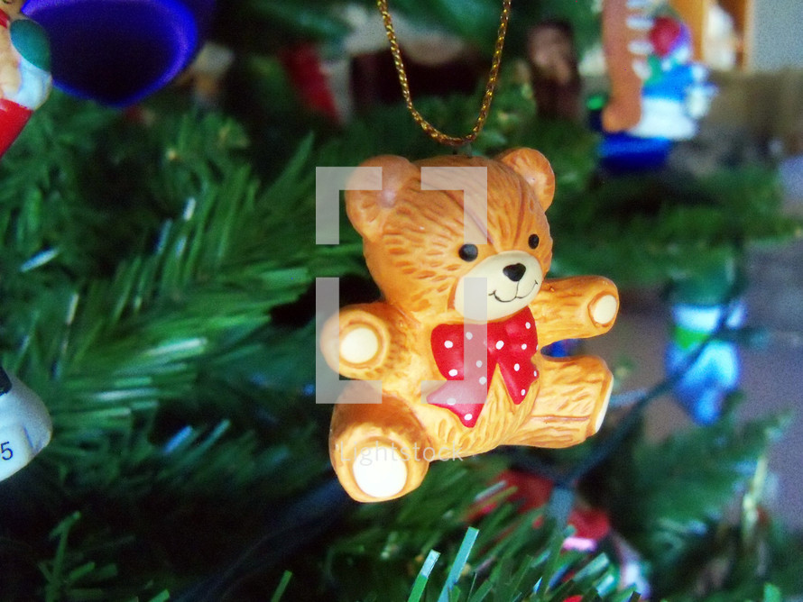 A close-up view of a Teddy Bear Christmas Tree ornament decoration adorning a Christmas Tree for the Christmas Holiday celebration for children and family. 