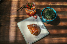 croissant and ice tea on a wood table 