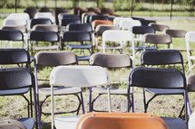 rows of folding chairs in a lawn 