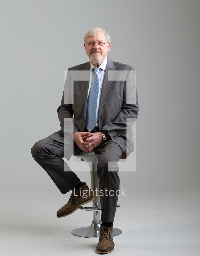 man with a beard in a suit and tie in studio portrait 