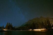 stars in the night sky above a lake 