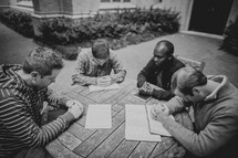 a group of men in a prayer circle during a Bible study