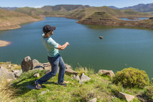 a man throwing a rock into a lake 