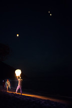 man releasing paper lanterns into the night sky