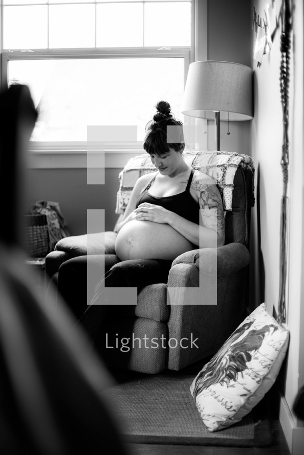 pregnant mother sitting on a chair 