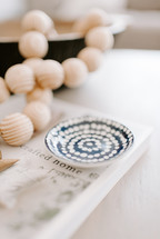 wooden beads, book, and bowl on a table 