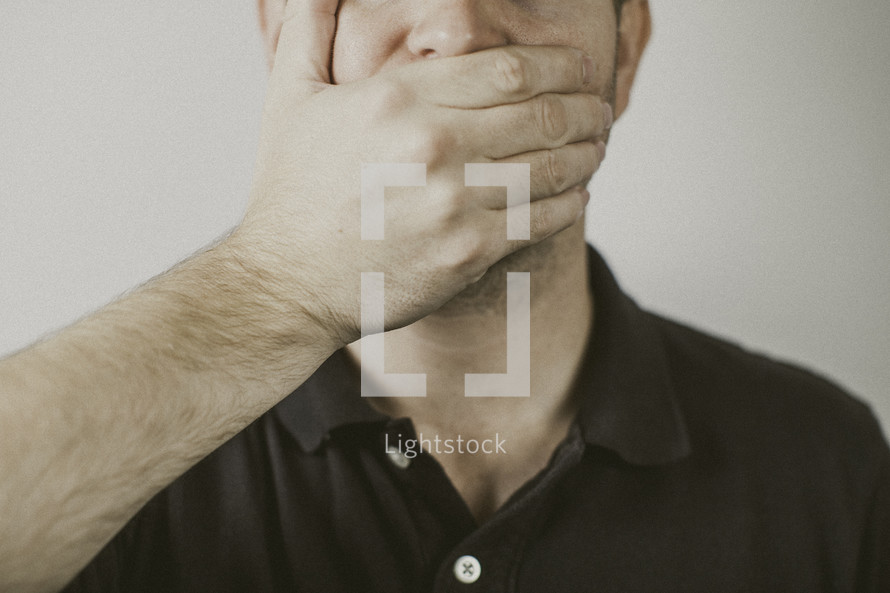 man covering his mouth with his hand 