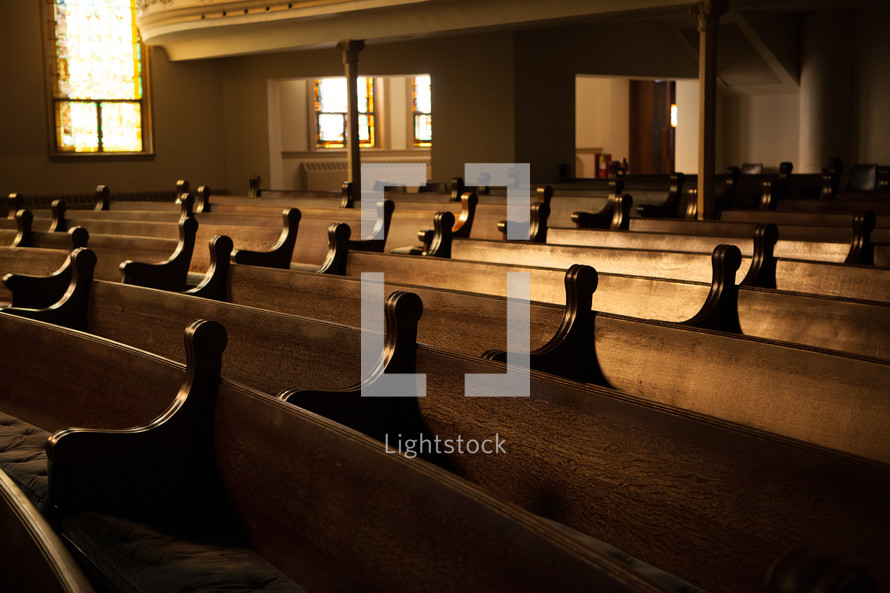 A church sanctuary filled with wooden pews.