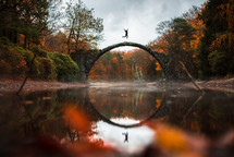 man jumping on a circular bridge 