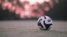 Soccer Ball Parallax sitting on Early Morning Field with Dew and Sunrise