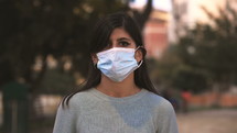 a young woman putting on a face mask 