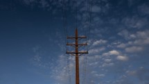 Timelapse of clouds moving beyond an electric power pole