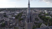 Drone orbiting near Saint Vitus Church, Neo-gothic Architectural Tower, Hilversum city in Background