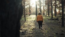 a woman walking through a forest 