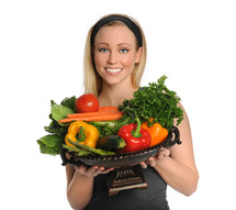 Woman holding a bowl of fresh vegetables.