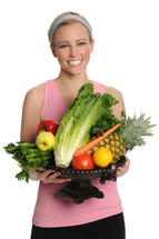 Smiling woman holding a bowl of produce.