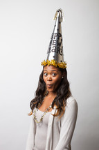 A woman wearing a Happy new Years party hat. 