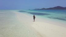 Man walks on white sand in Fiji
