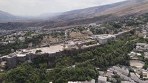 Gjirokastër Castle on hilltop overlooking UNESCO city; panoramic aerial view