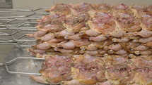 Seasoned raw chicken on metal skewers. 