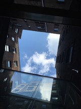 looking up at the sky between city buildings 