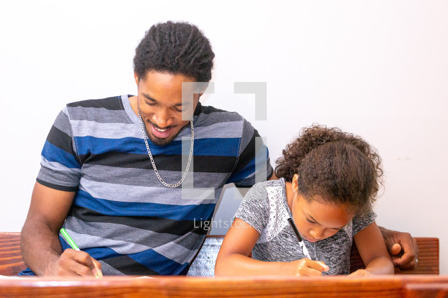 a father coloring with his daughter 