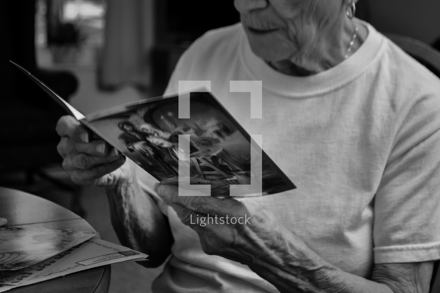 elderly woman reading a Christmas card 