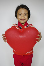 a child holding a red heart 