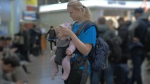 Cute baby in a baby carrier at airport