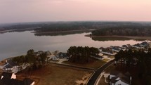 Aerial of Neighborhood with Lake at Sunset