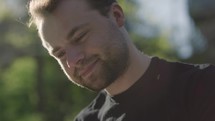 Young man reading his Bible outside on a warm sunny day