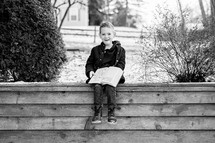 a boy reading a Bible outdoors in winter 
