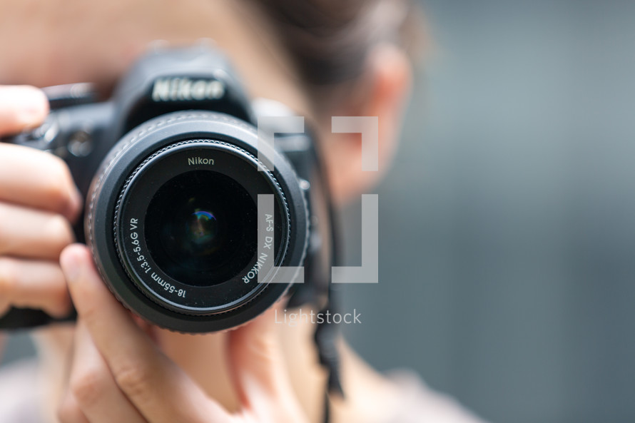 Close up of photographer taking picture with dslr camera