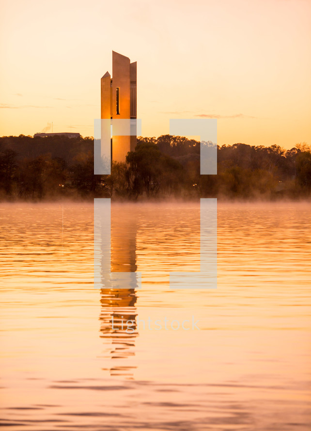 tower across a lake at sunset 