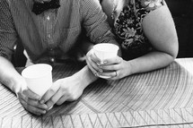 engaged couple snuggling drink cups of water 