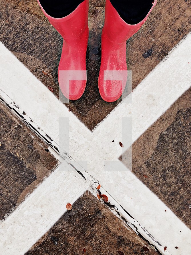 X marks the spot - rain boots and wet pavement 
