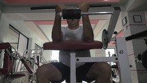 Senior man doing exercise on training machine in gym