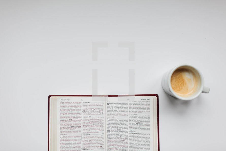open Bible and mug on a white background 