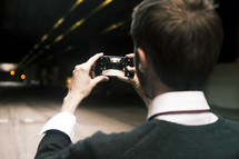 a man taking a picture of cars in a tunnel with his phone 