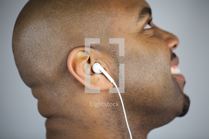 side profile of a man with earbuds 