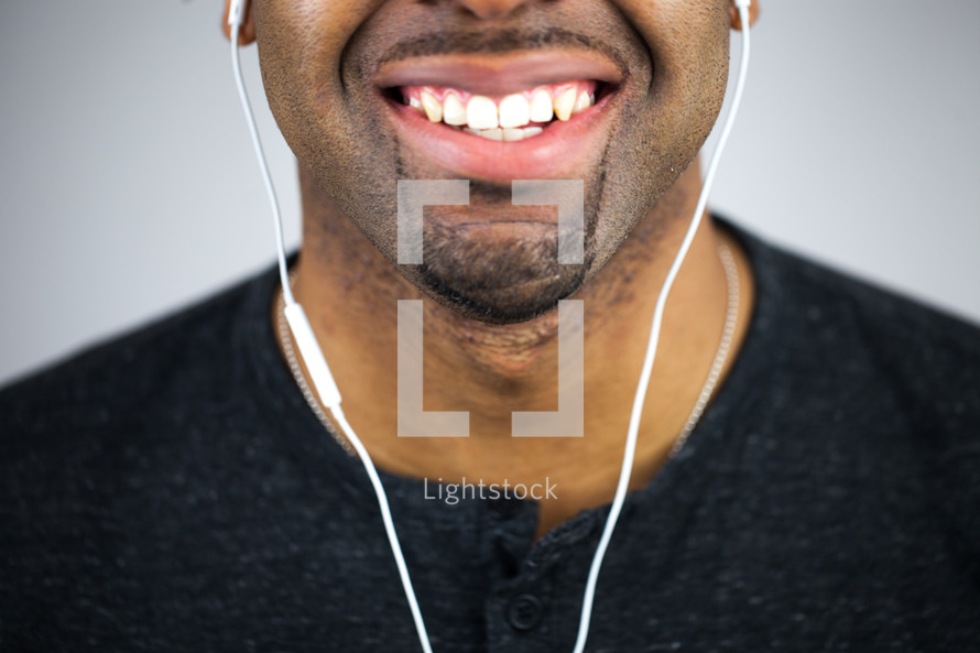 face of a man with earbuds 