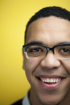 face of a smiling man in reading glasses 
