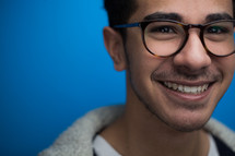 face of a smiling man with reading glasses 