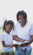 mother and daughter reading a Bible together 