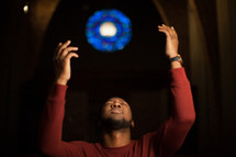 a man with raised hands in church 