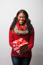A woman holding a wrapped Christmas gift. 