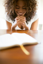 woman in prayer over the pages of a Bible