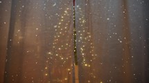 Christmas Tree hidden behind a house curtain and snow