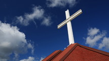 Time lapse view of cross on church rooftop as clouds pass by
